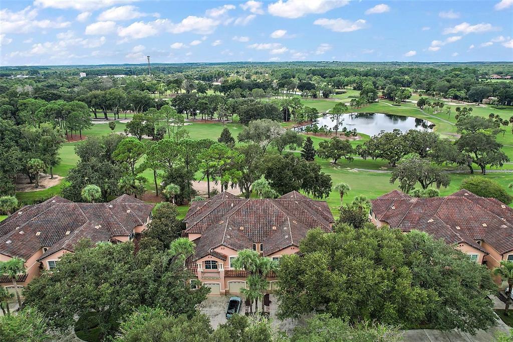 An aerial view of a multi-unit residential building overlooking a golf course and pond — 802 CAMINO REAL BOULEVARD UNIT 802, HOWEY IN THE HILLS, FL
