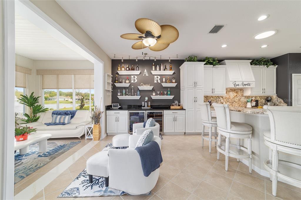 A kitchen and living area feature white cabinetry, a wet bar, and a ceiling fan — 9375 SE 125TH STREET, SUMMERFIELD, FL