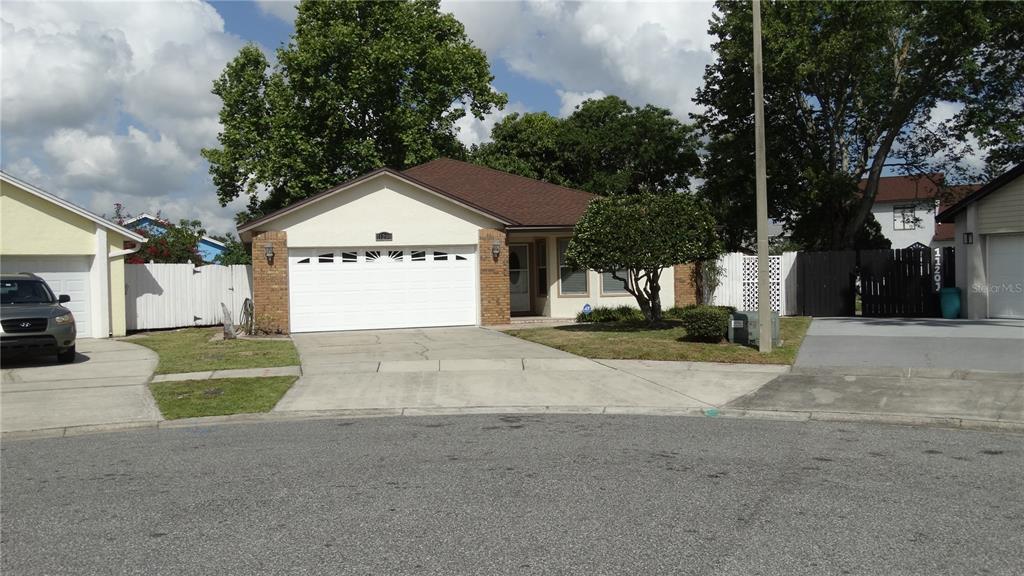 A single-story house with a white garage, brick accents, and a driveway from the street — 11200 TORBERT COURT, ORLANDO, FL