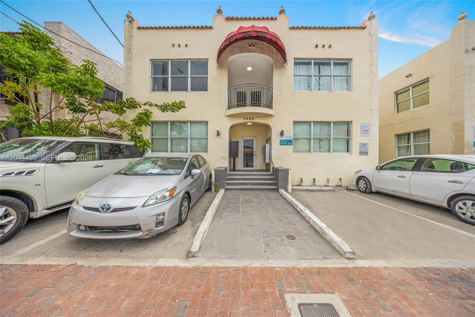 A two-story stucco apartment building features a central arched entryway and a small balcony — 1521 SW 7th St, Miami FL 33135, MIAMI, FL