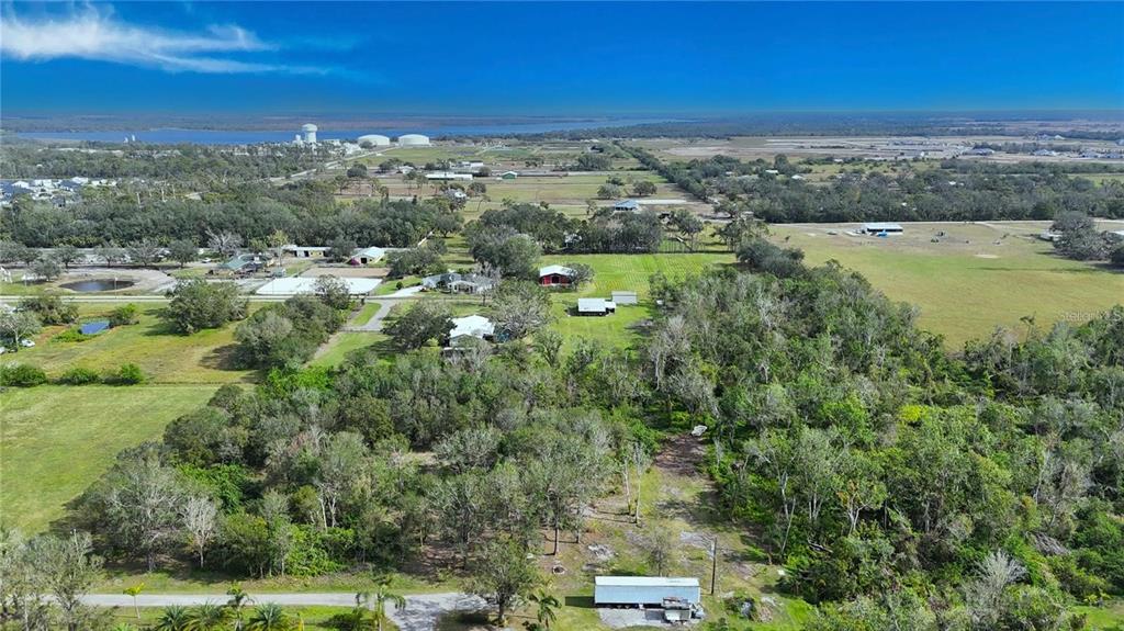 An aerial view shows a rural property with a house, outbuildings, and surrounding wooded land — 16678/16620 WATERLINE ROAD ROAD, BRADENTON, FL