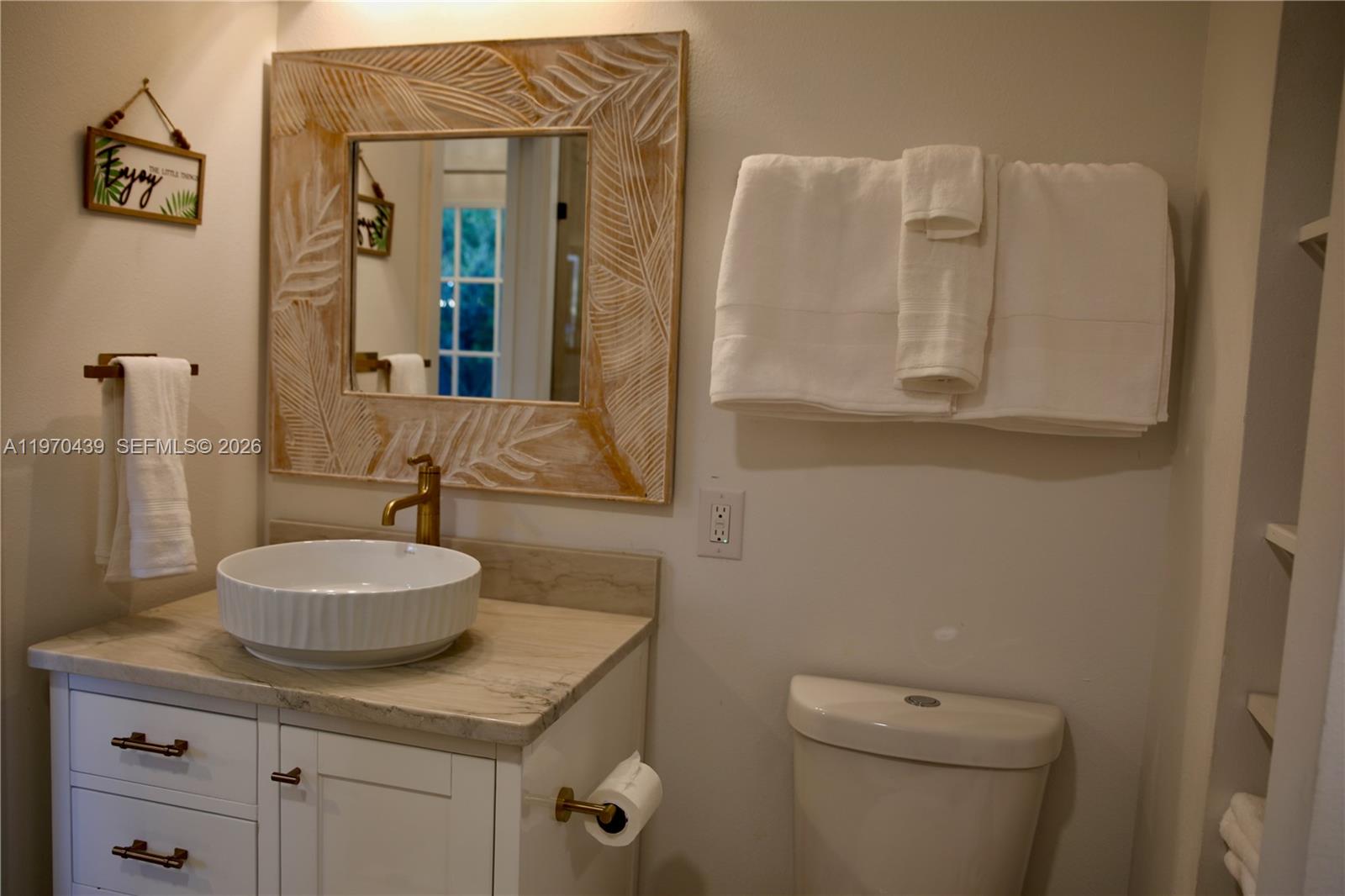A bathroom features a white vanity with a vessel sink, a decorative mirror, and towels — 124 Aucila RD., Cocoa Beach FL 32931, COCOA BEACH, FL