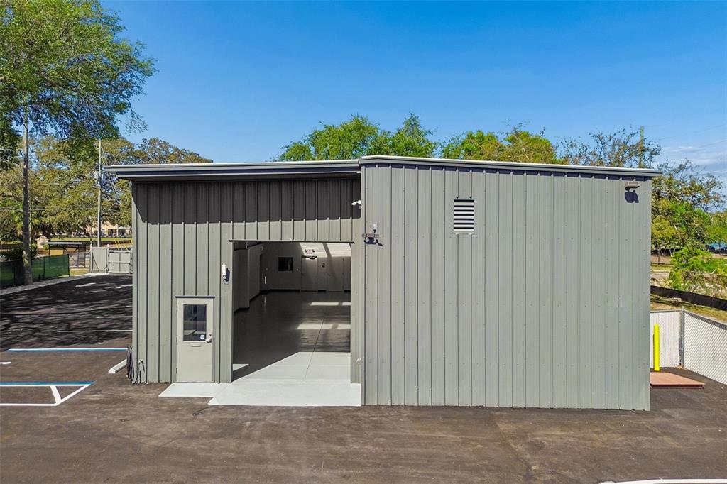 A gray metal industrial building with a large open bay door and a side entrance — 1453 S MARTIN LUTHER KING JR AVENUE, CLEARWATER, FL
