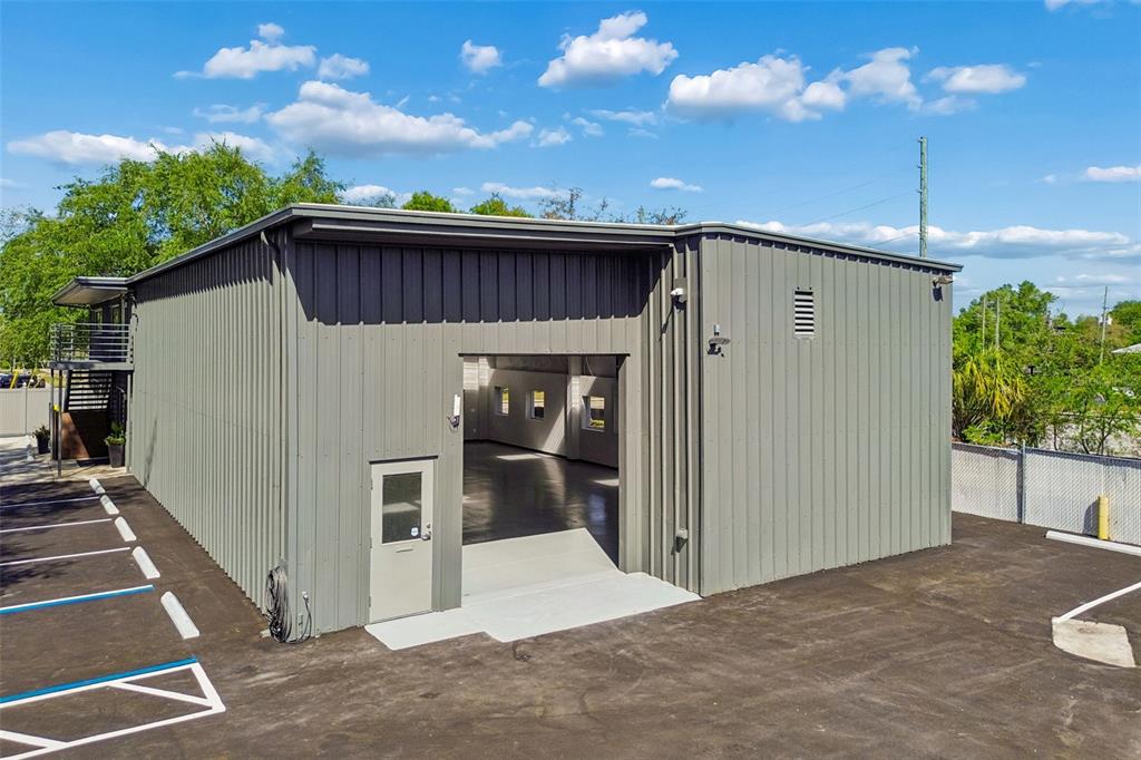 A gray metal industrial building features a pedestrian door and a large open bay entrance — 1453 S MARTIN LUTHER KING JR AVENUE, CLEARWATER, FL
