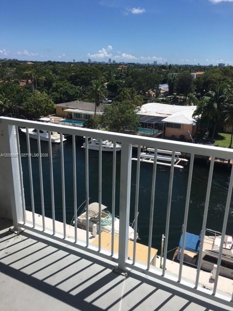 A balcony view overlooks a canal with several boats docked behind residential houses — NORTH MIAMI, FL
