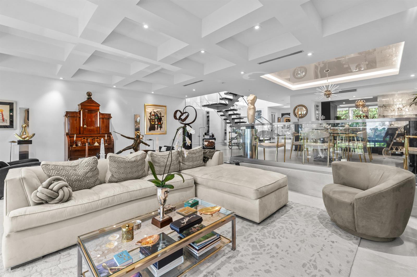 A modern living room features a white sectional sofa, glass coffee table, and a floating staircase — 2335 S Ocean Boulevard # C9, Palm Beach FL 33480, PALM BEACH, FL