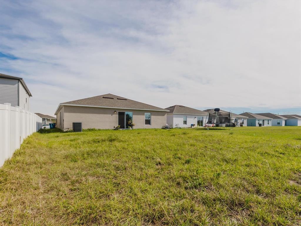 A bedroom features a green bedspread, upholstered headboard, area rug, and an attached bathroom — 288 TOWNS CIRCLE, HAINES CITY, FL