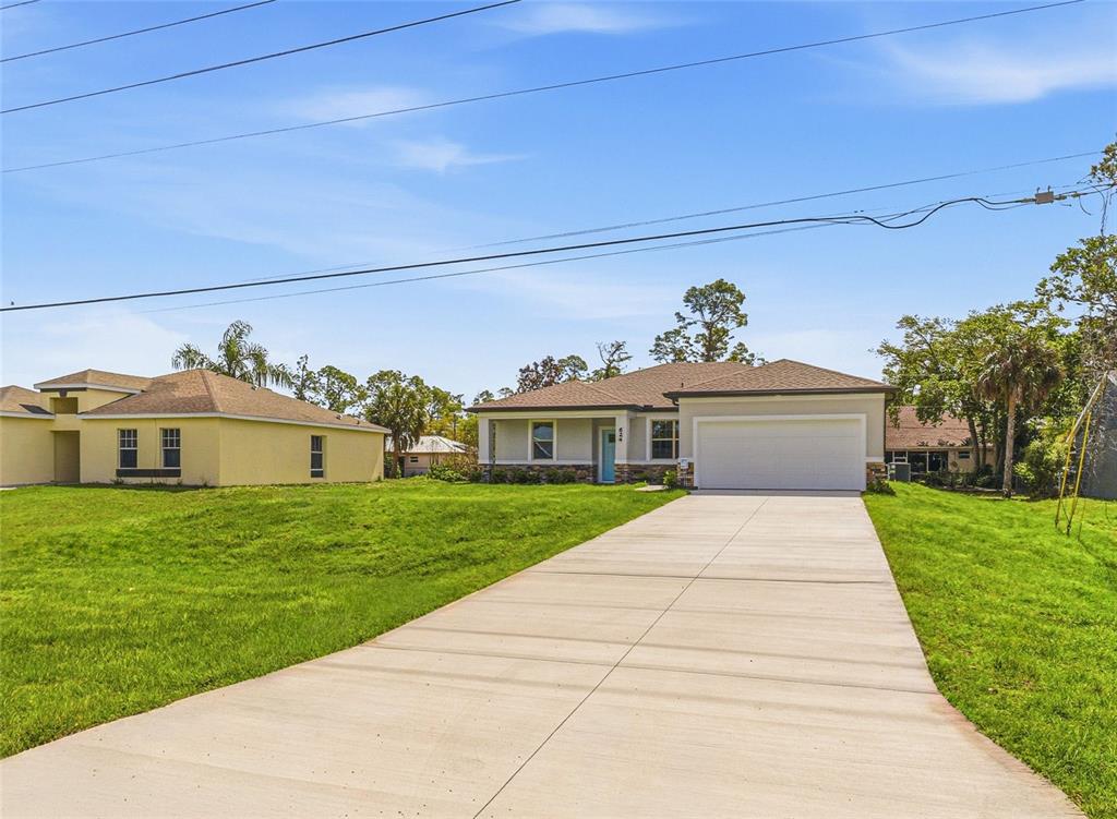 A single-story house with a light-colored exterior, a two-car garage, and a concrete driveway — 2624 ATWATER DRIVE, NORTH PORT, FL