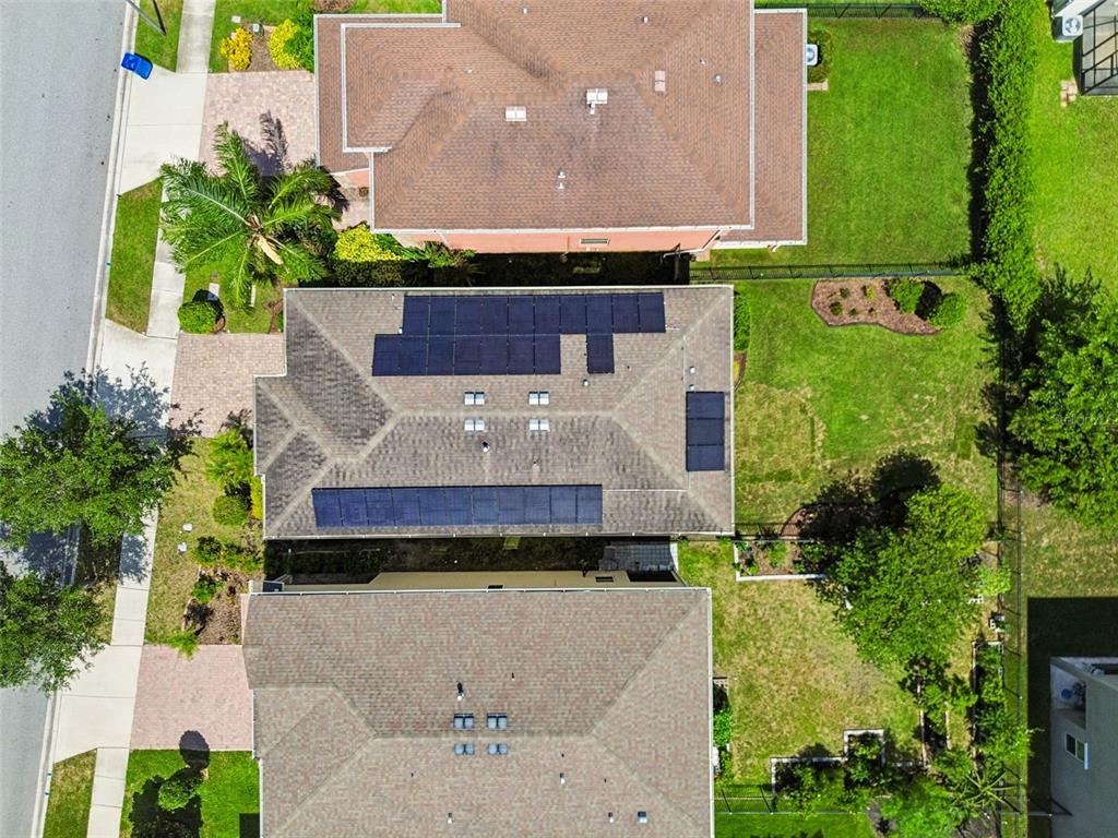An aerial view shows three residential houses with shingled roofs and solar panels — 17576 TERRAZZO WAY, LAND O LAKES, FL