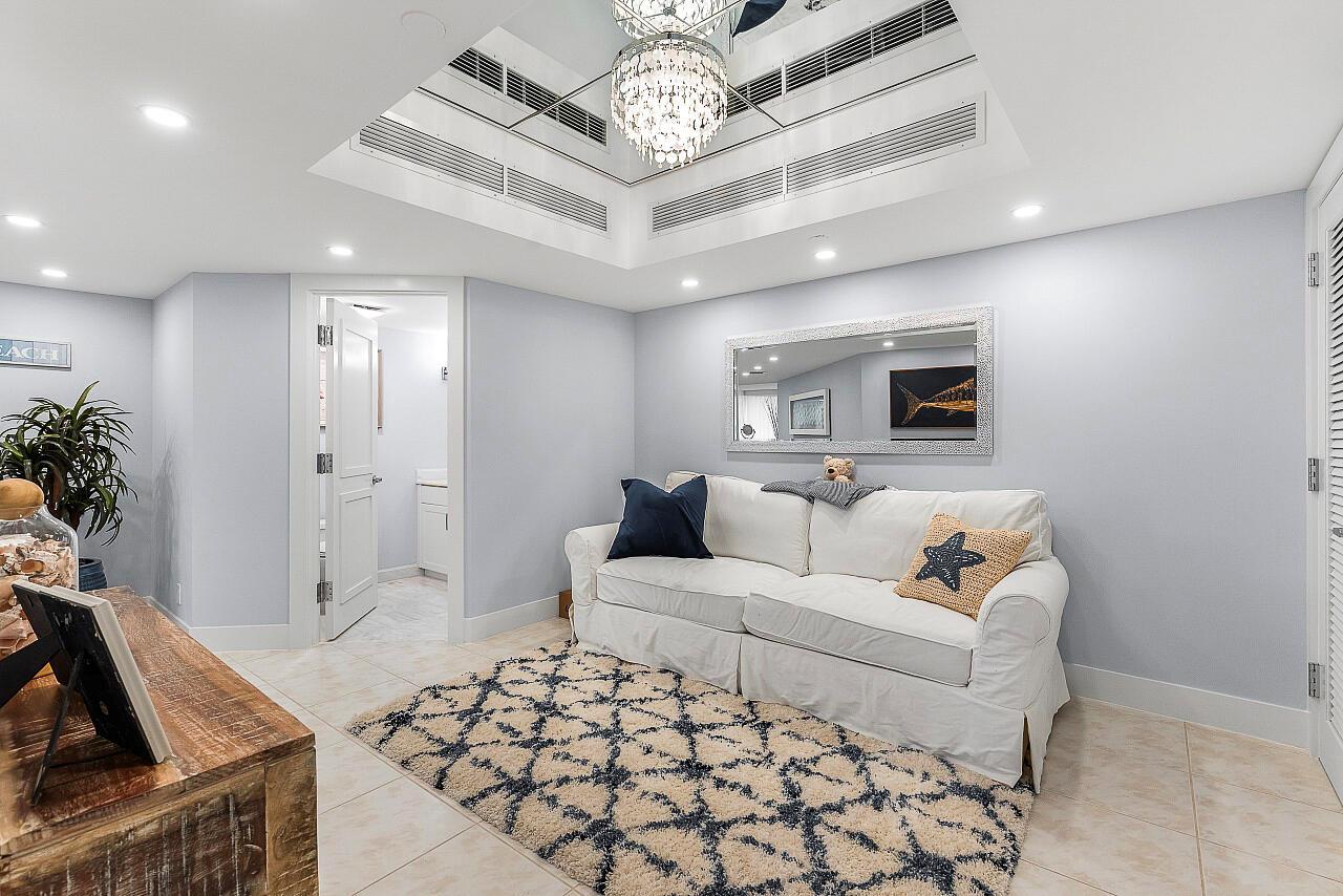A living room features a white sofa, a patterned rug, and a mirrored ceiling tray — 100 Lakeshore Drive # 252, North Palm Beach FL 33408, NORTH PALM BEACH, FL