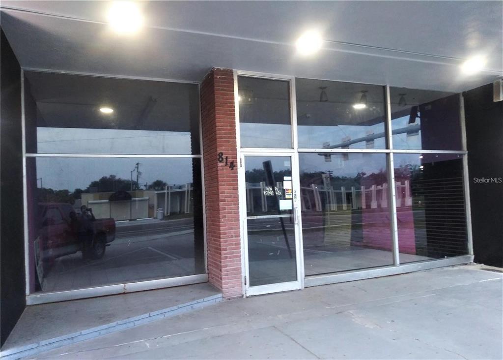 The exterior of a commercial storefront features large glass windows and a brick pillar — 814 COURT STREET, CLEARWATER, FL