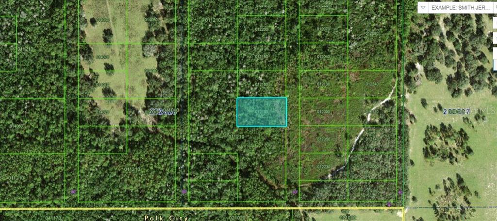 This is a satellite map view showing a highlighted rectangular parcel of undeveloped land — COMMONWEALTH AVE N, POLK CITY, FL