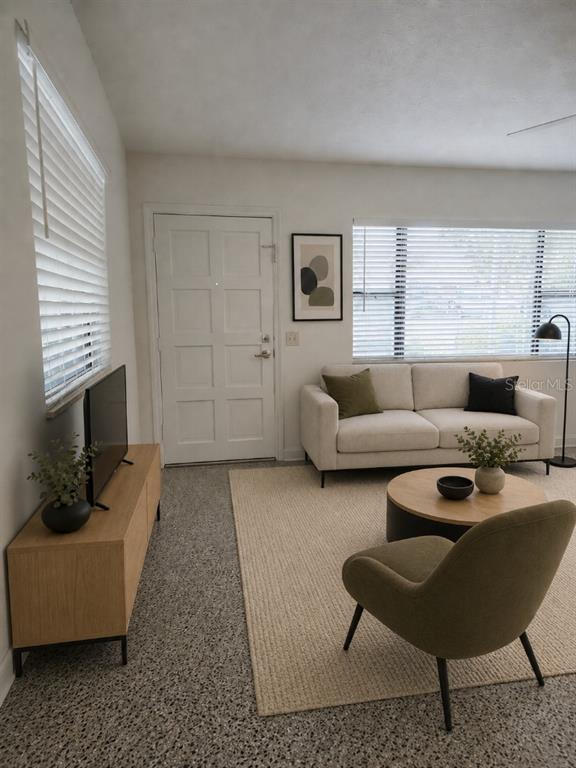 A living room features a white sofa, a green armchair, a television, and terrazzo flooring — 1005 N BRACEWELL DRIVE, PLANT CITY, FL