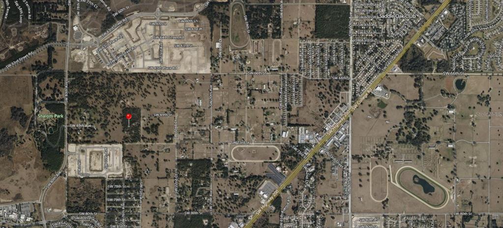 This is an aerial map view showing a plot of land marked with a red pin — 7589 SW 73RD STREET, OCALA, FL
