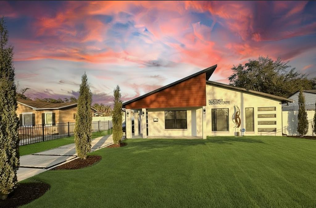A modern single-story house with a slanted roof, wood-paneled accent, and a manicured front lawn — 860 N DENNING DRIVE, WINTER PARK, FL