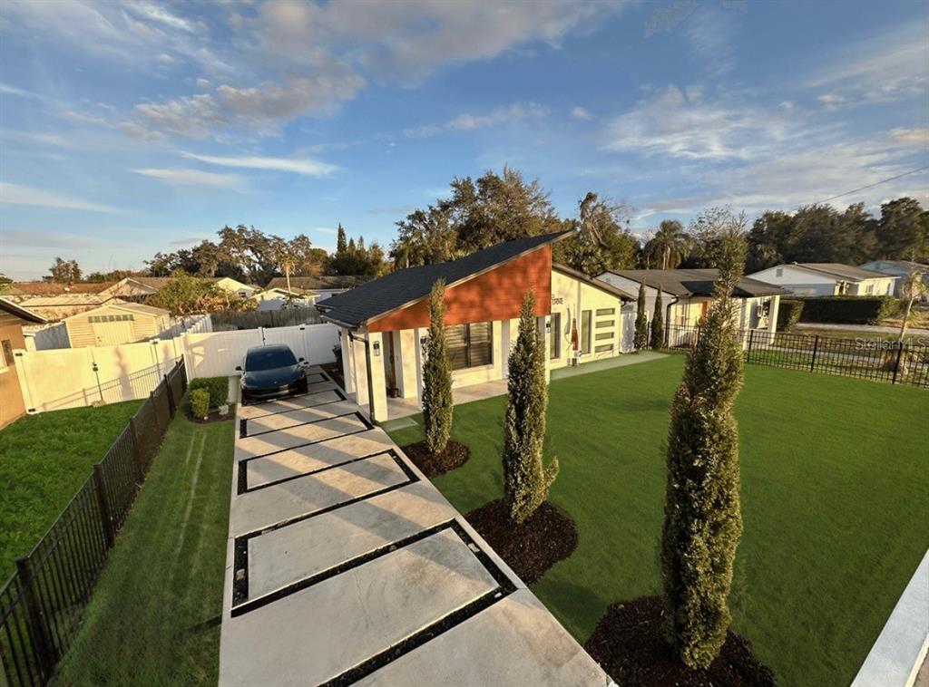 An elevated view of a modern house with a geometric concrete driveway and artificial turf — 860 N DENNING DRIVE, WINTER PARK, FL