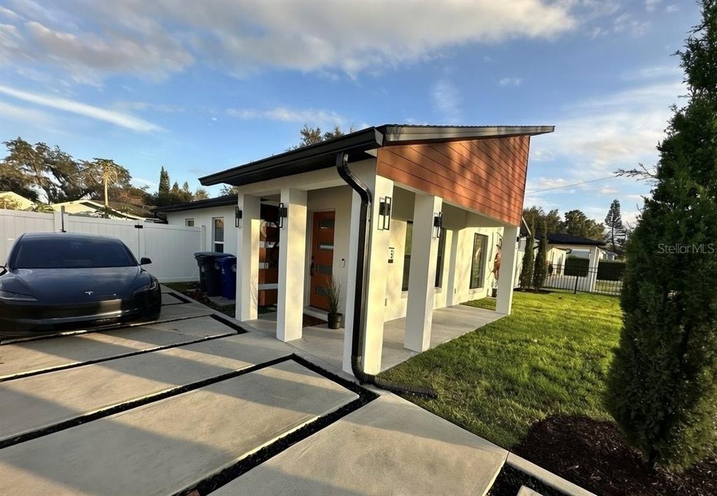 A modern, single-story house with a slanted roof, white pillars, and a paved driveway — 860 N DENNING DRIVE, WINTER PARK, FL