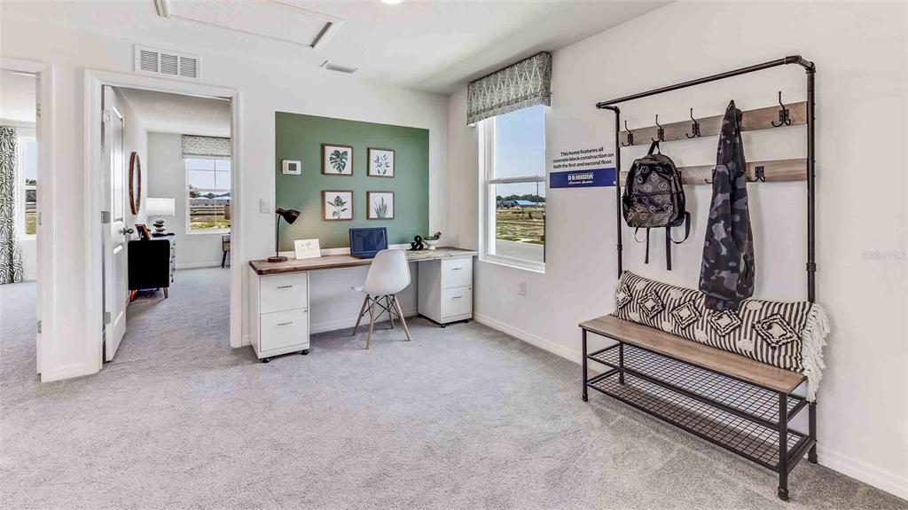 A home office features a desk, a coat rack bench, and a green accent wall — 17950 ACORN DROP ROAD, LAND O LAKES, FL