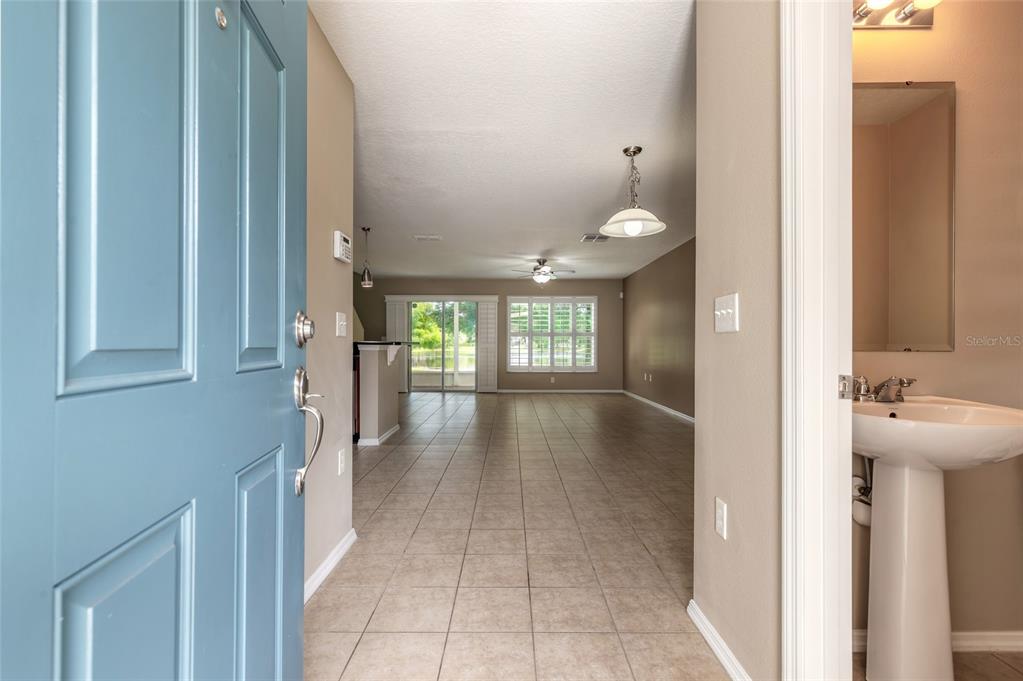 An entryway opens into a tiled living area with a view of a rear patio — 2669 SICILY DRIVE, NEW SMYRNA BEACH, FL