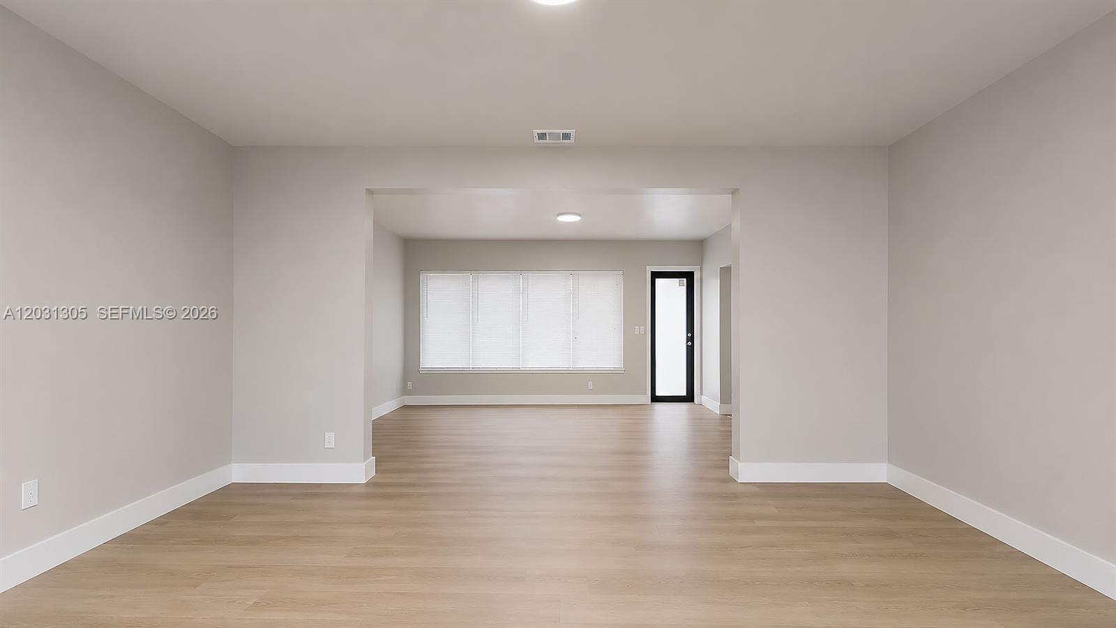 An empty room with light-colored walls, wood-look flooring, and a doorway leading to another space — 101 W 11th St # 8, Hialeah FL 33010, HIALEAH, FL