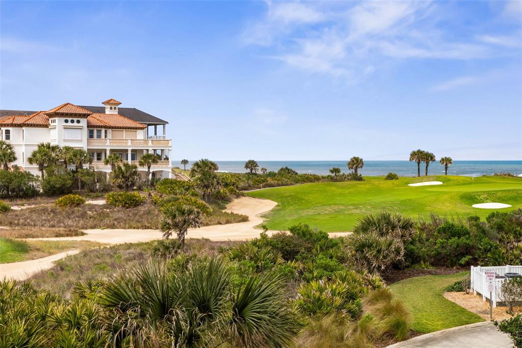 A multi-story villa overlooks a coastal golf course with sand traps and the ocean beyond — 400 CINNAMON BEACH WAY UNIT 335, PALM COAST, FL