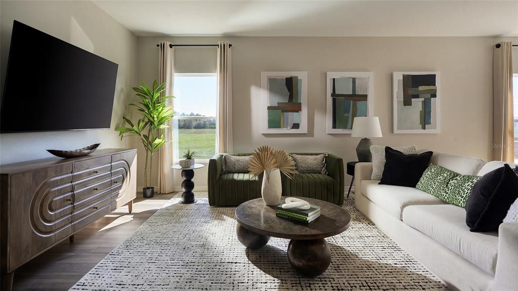 A living room features a large television, a white sofa, green chairs, and a coffee table — 9150 BENT BRANCH, DADE CITY, FL