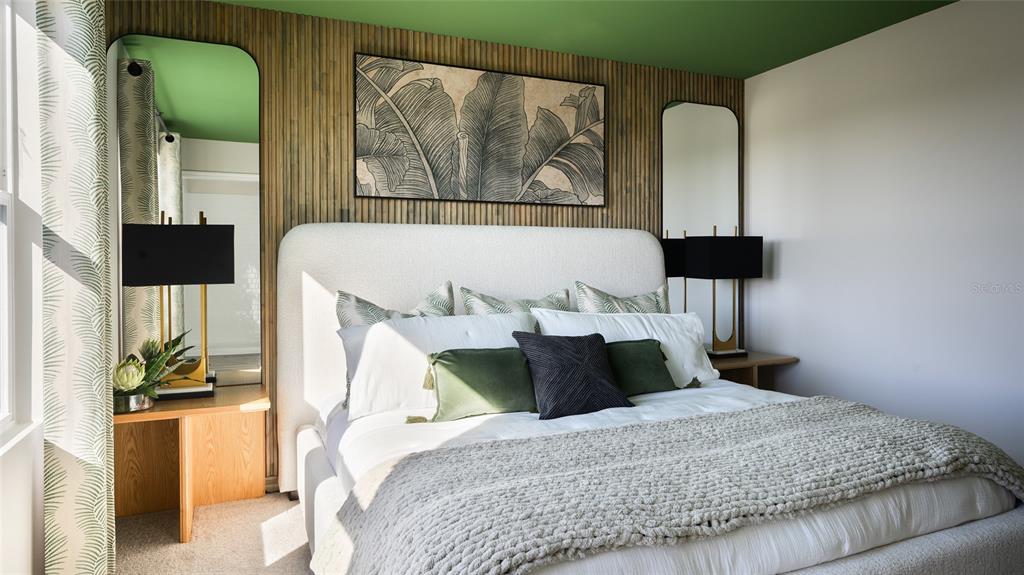 A bedroom features a white upholstered bed, wood-slat accent wall, and green ceiling — 9150 BENT BRANCH, DADE CITY, FL