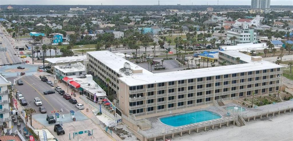 An aerial view shows a multi-story hotel building with a swimming pool facing the beach — 219 S ATLANTIC AVENUE UNIT 412, DAYTONA BEACH, FL