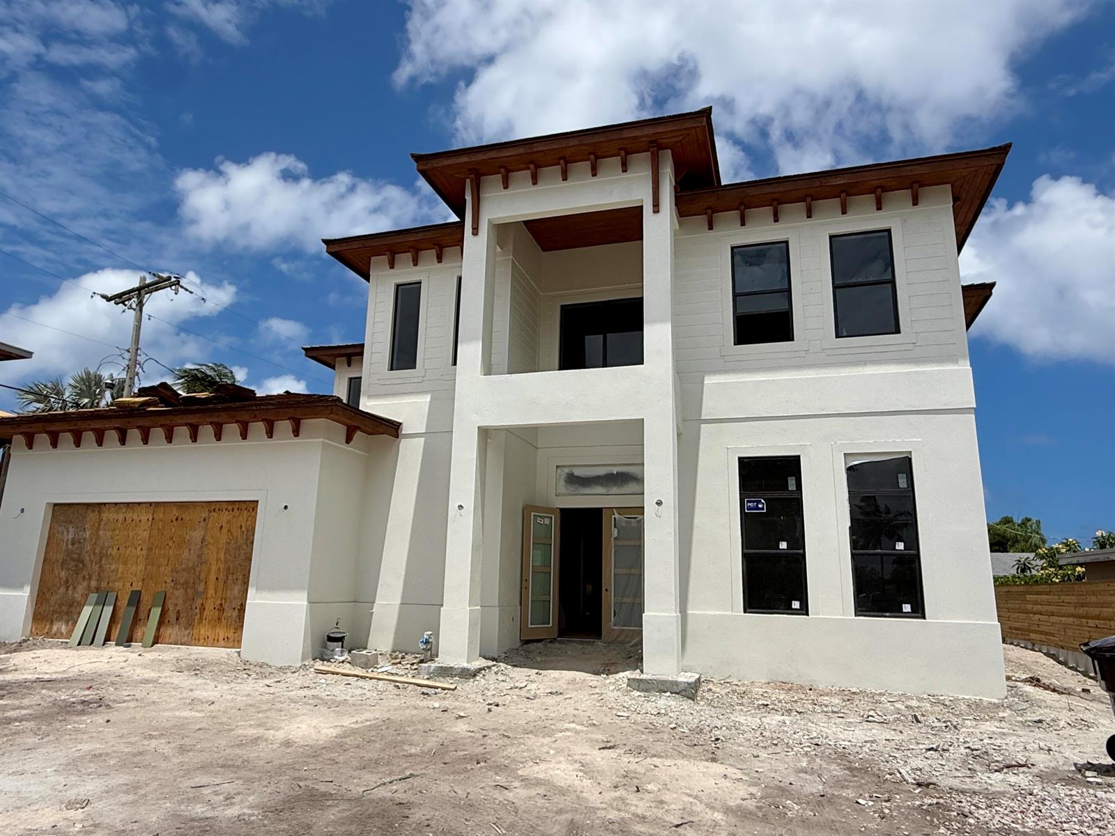 A two-story house under construction with white stucco walls, dark window frames, and wood eaves — 6316 S Olive Avenue, West Palm Beach FL 33405, WEST PALM BEACH, FL