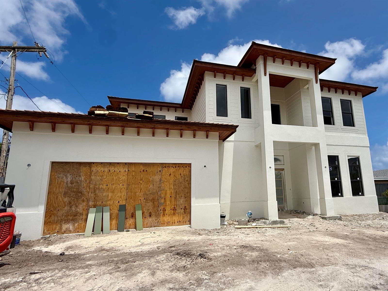 A two-story house under construction with a plywood-covered garage and exposed wooden roof rafters — 6316 S Olive Avenue, West Palm Beach FL 33405, WEST PALM BEACH, FL