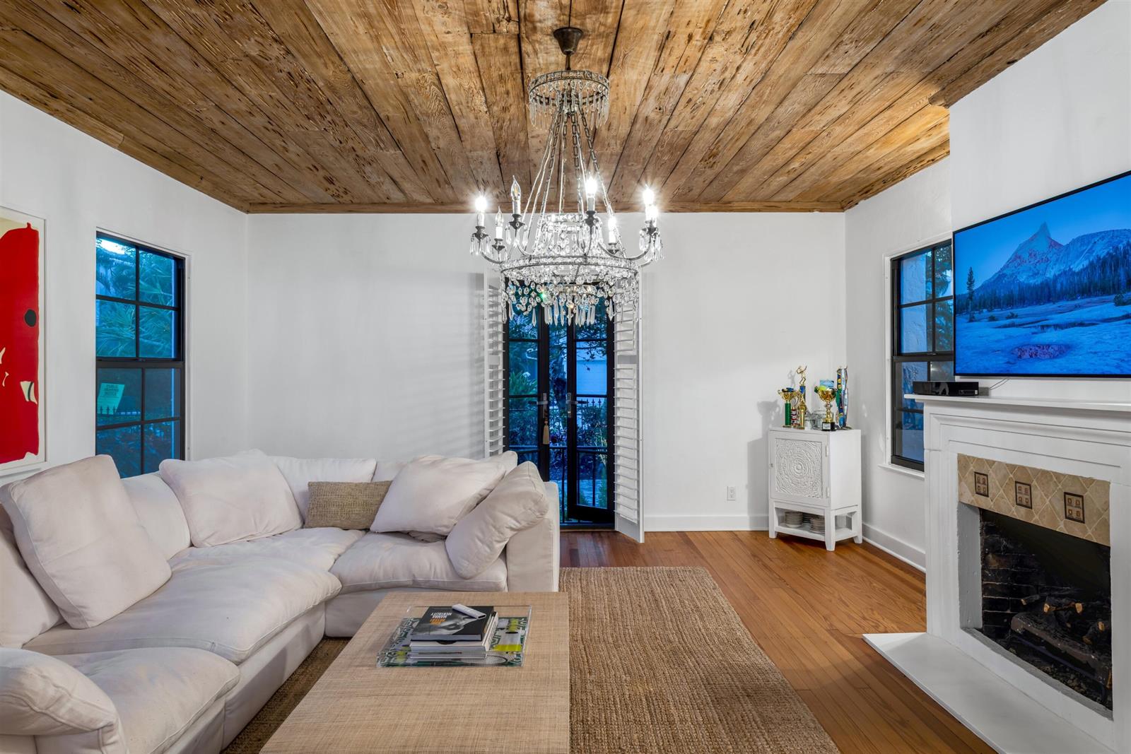 A living room features a white sectional sofa, crystal chandelier, wood ceiling, and a fireplace — 755 Alamanda Street, Boca Raton FL 33486, BOCA RATON, FL