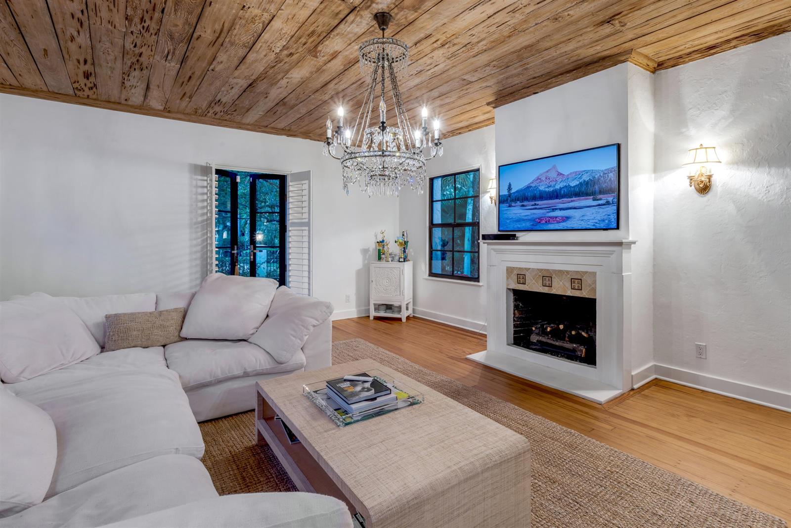 A living room features a wood-plank ceiling, a crystal chandelier, a white sofa, and a fireplace — 755 Alamanda Street, Boca Raton FL 33486, BOCA RATON, FL