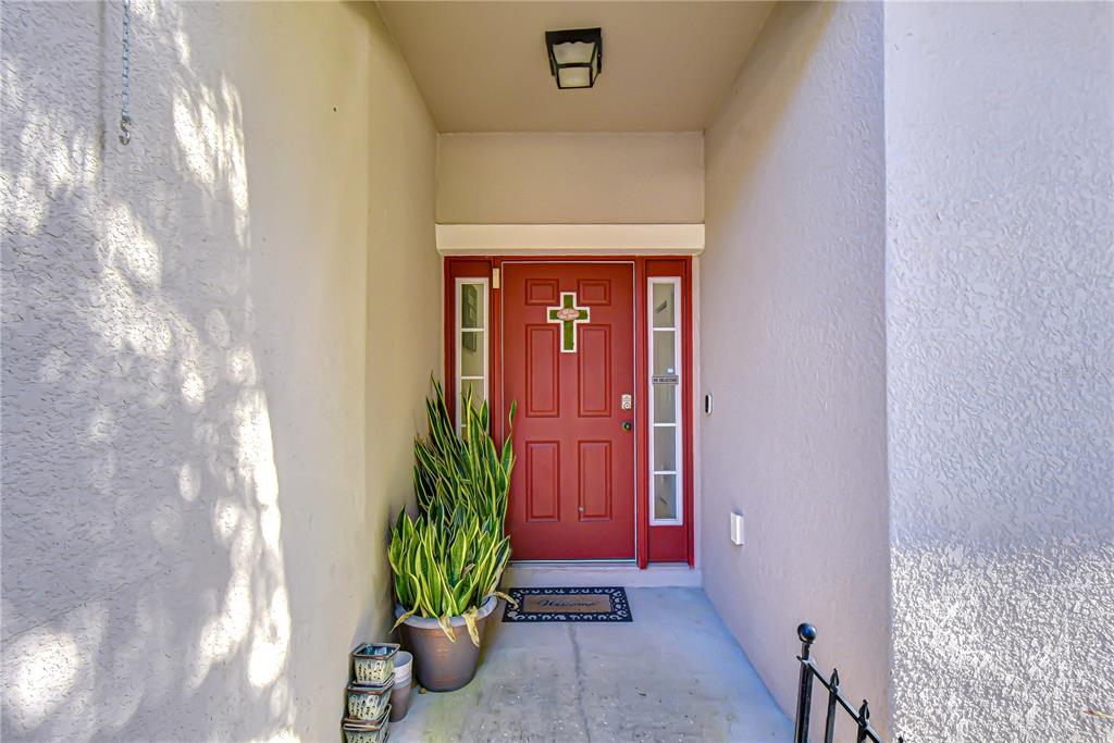 A single-story house with a beige stucco exterior, a two-car garage, and red shutters — 6252 TWIN BRIDGES DRIVE, ZEPHYRHILLS, FL