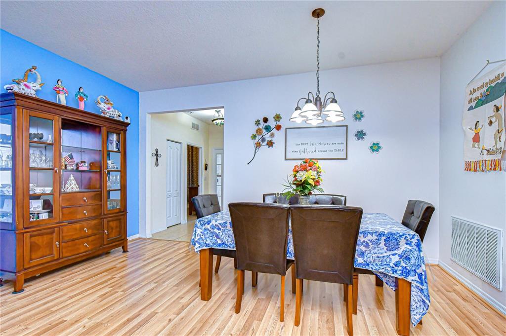 An entryway features a white front door with sidelights, tiled flooring, and a wall sign — 6252 TWIN BRIDGES DRIVE, ZEPHYRHILLS, FL