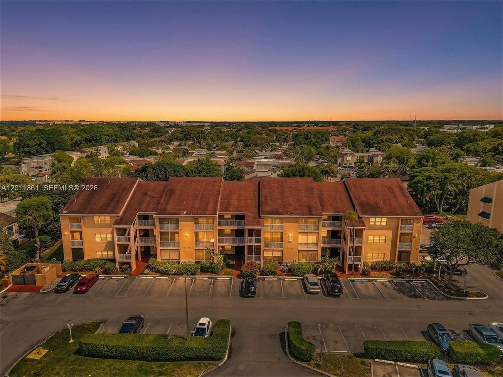 An aerial view of a three-story apartment building with a parking lot in front — 15325 SW 106th Ter # 636, Miami FL 33196, MIAMI, FL