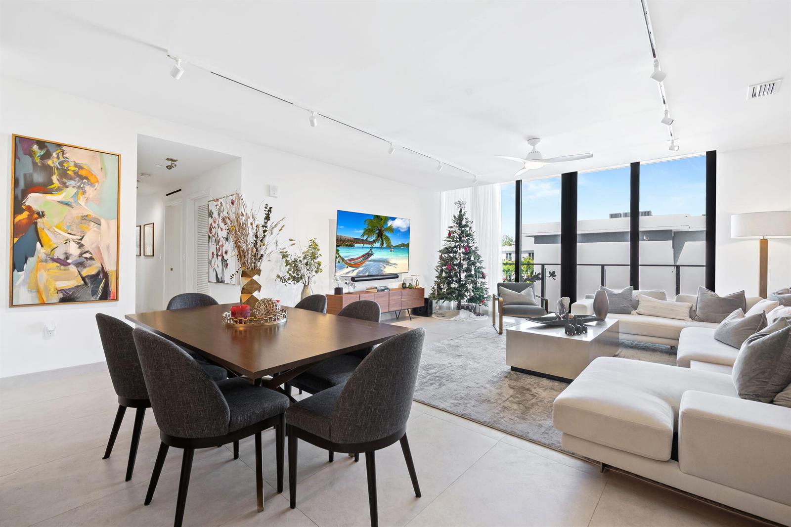 A modern living and dining room features a large sectional sofa, dining table, and Christmas tree — 3581 E Glencoe Street # 408, Miami FL 33133, MIAMI, FL