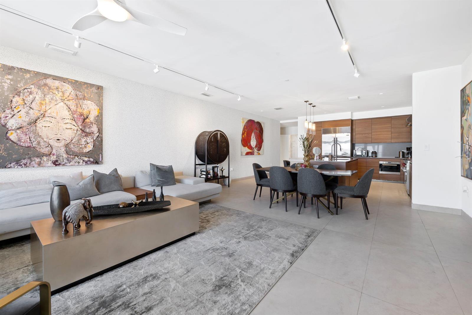 A modern open-concept living and dining area with tile floors and contemporary artwork — 3581 E Glencoe Street # 408, Miami FL 33133, MIAMI, FL