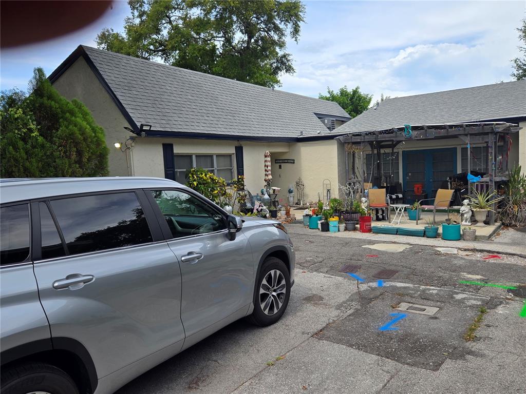 A silver SUV is parked in front of a single-story house with a pergola patio — 1118 HARRIS LANE, CLEARWATER, FL