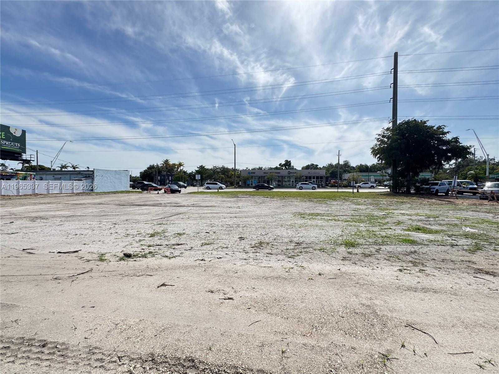 A large, vacant, sandy lot sits in front of a commercial shopping center — 2621 Griffin Rd, Dania Beach FL 33312, DANIA BEACH, FL
