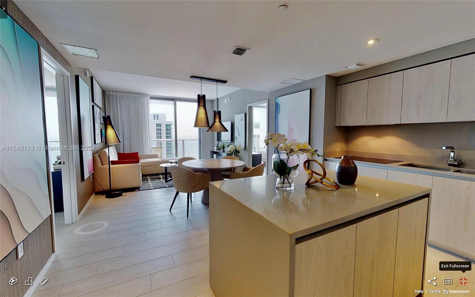 A modern open-concept kitchen and living area with light wood cabinetry and a central island — 4010 S Ocean Dr # R703, Hollywood FL 33019, HOLLYWOOD, FL