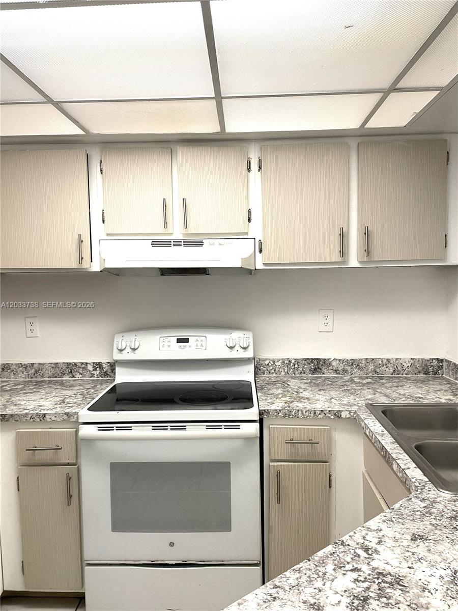 A kitchen features light wood-grain cabinets, white appliances, and speckled laminate countertops — 8255 SW 152nd Ave # 405, Miami FL 33193, MIAMI, FL