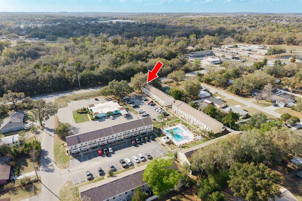 An aerial view shows a multi-building apartment complex with a swimming pool and parking lot — 37236 EMBASSY PARK LANE UNIT 1, DADE CITY, FL
