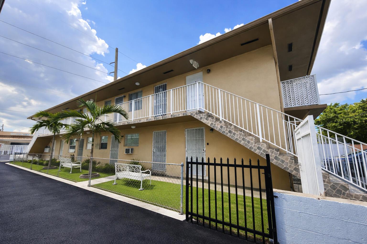 A two-story apartment building with a white exterior staircase and a fenced front lawn — 715 W 29th Street, Hialeah FL 33012, HIALEAH, FL