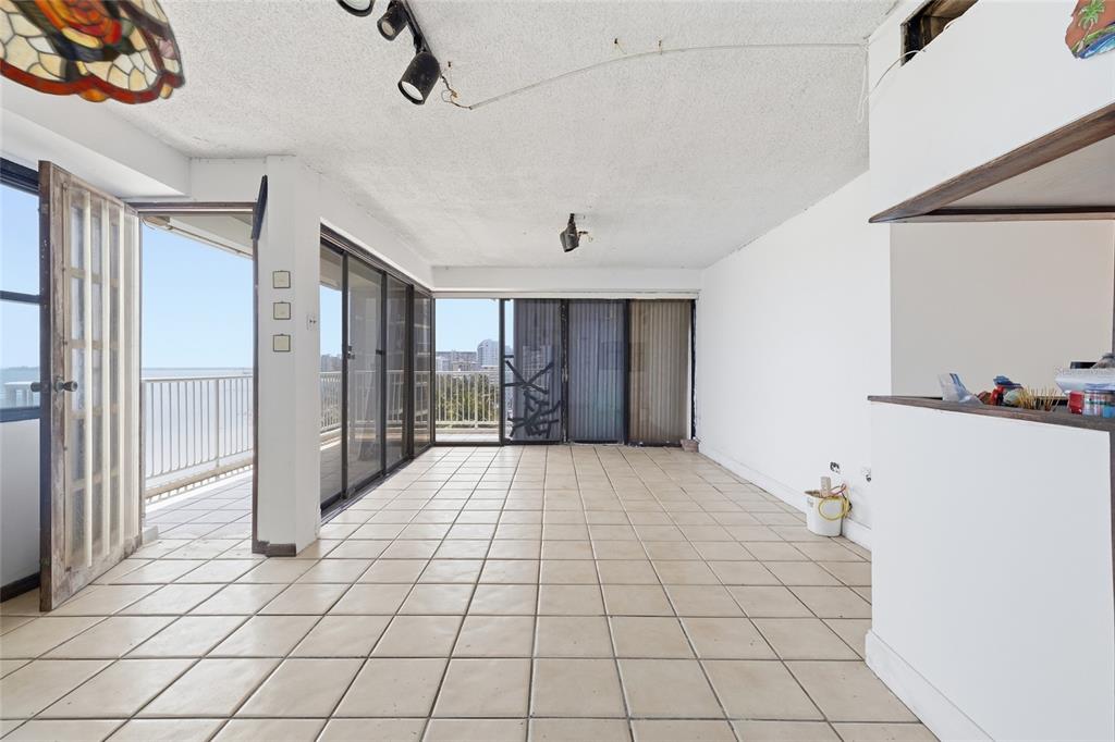 An empty room with beige tile flooring, white walls, and sliding glass doors to a balcony — 4633 ISLA VERDE AVE UNIT 803, CAROLINA, PR
