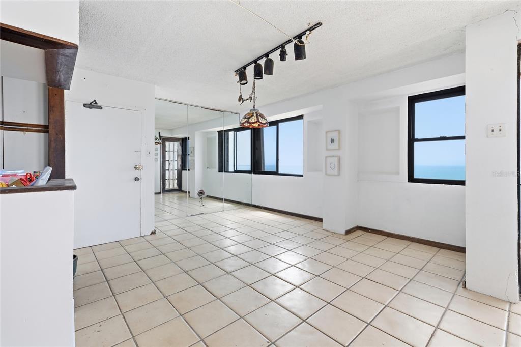 A bright room with white walls, tiled floors, a mirrored wall, and ocean views — 4633 ISLA VERDE AVE UNIT 803, CAROLINA, PR