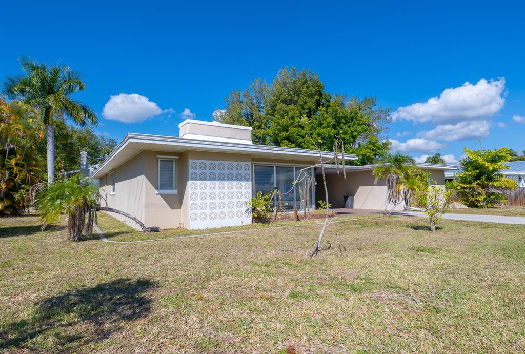 A single-story house with a decorative concrete block screen wall and a flat roof — 410 W CHARLOTTE AVENUE, PUNTA GORDA, FL
