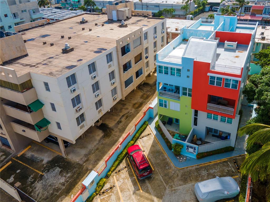 An aerial view shows two multi-story apartment buildings with a parking area between them — 707 OCEAN DRIVE UNIT A-4, LUQUILLO, PR