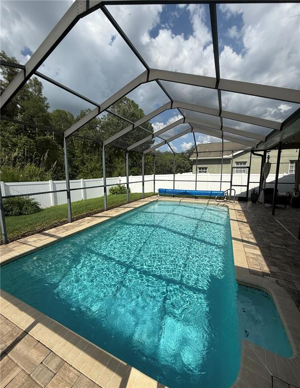 A single-story house with a tan exterior, arched entryway, and a landscaped front yard — 12603 ROSELAND DRIVE, NEW PORT RICHEY, FL