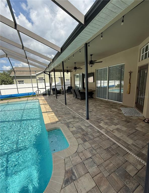 An entryway features light wood-look flooring, double front doors with oval glass, and a geometric chandelier — 12603 ROSELAND DRIVE, NEW PORT RICHEY, FL