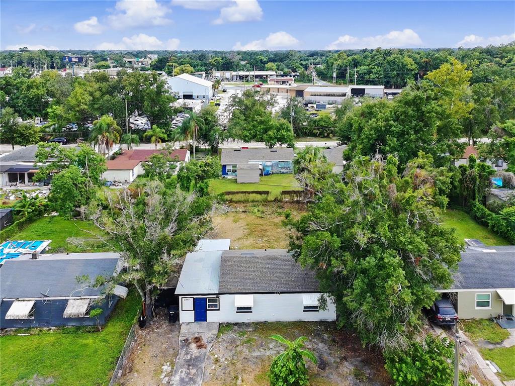 An aerial view shows a single-story house with a blue door and a large backyard — 2848 W HARWOOD STREET, ORLANDO, FL